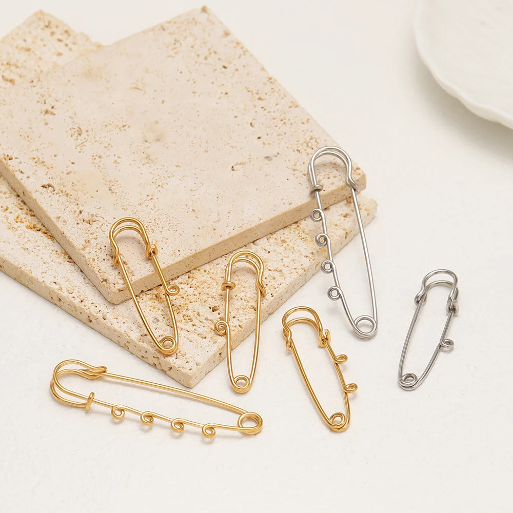 Assorted silver and gold multi-hole safety pin brooch fasteners with safety clips