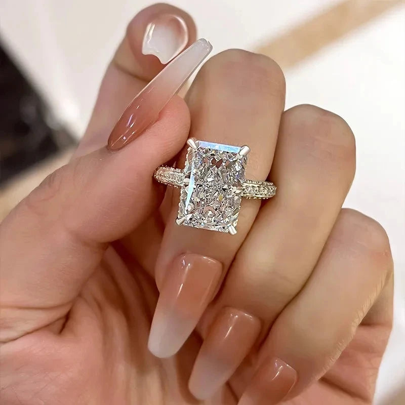 Rectangle-cut CZ ring, silver-tone openwork sides and square bezel, worn on hand