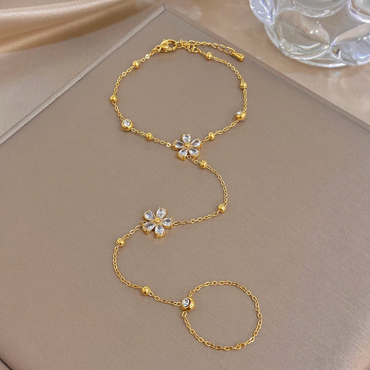 Gold-plated flower charm bracelet with connected finger ring chain