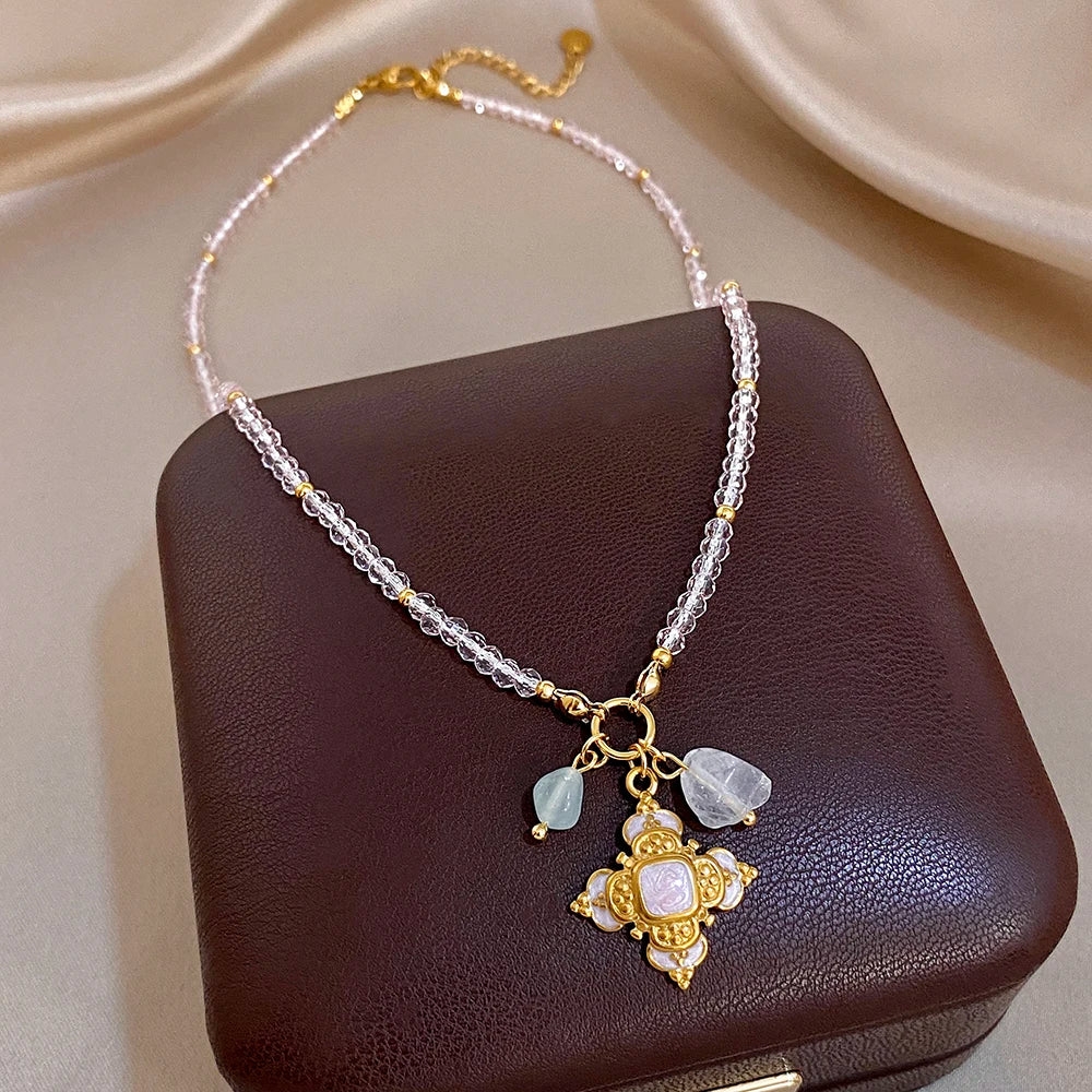 Gold-tone cross charm necklace with clear crystal drops on a silver beaded chain
