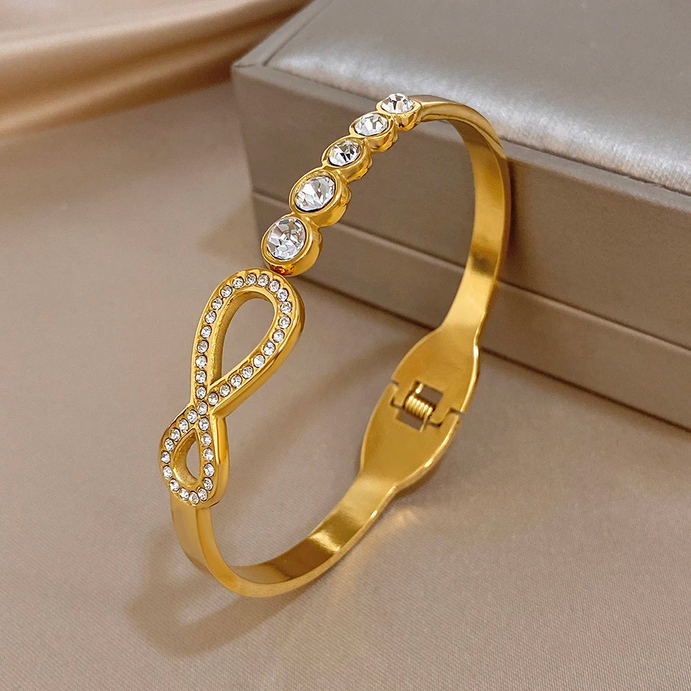 Gold-tone rhinestone infinity cuff bracelet with round crystal line accents and clasp