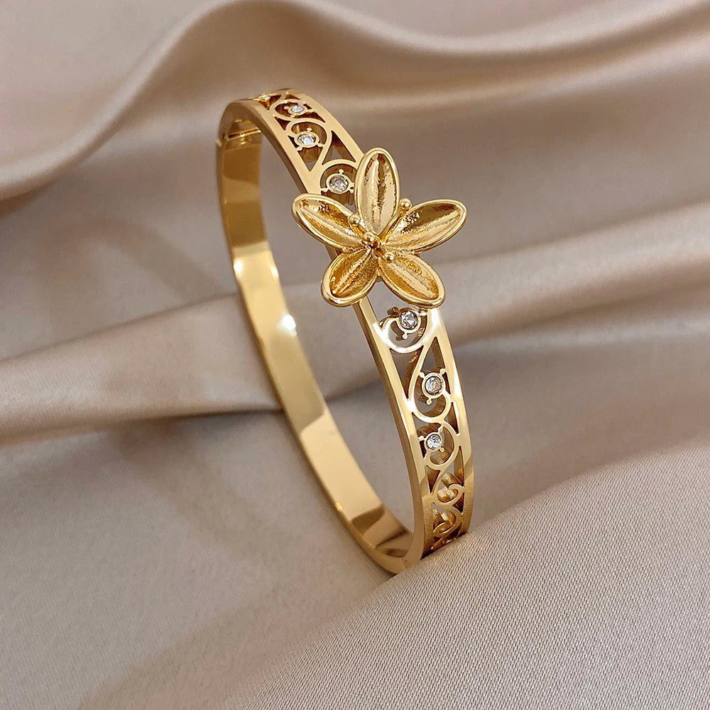 Gold-plated hollow flower cuff bangle with etched filigree and crystal accents