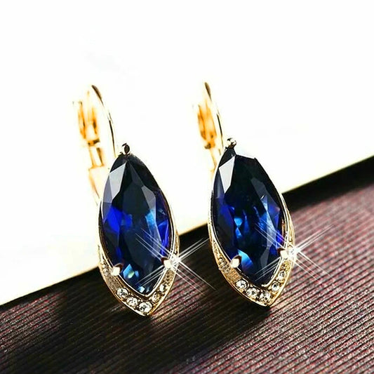 Gold-tone drop earrings with navy blue marquise crystal centers and clear sparkle border