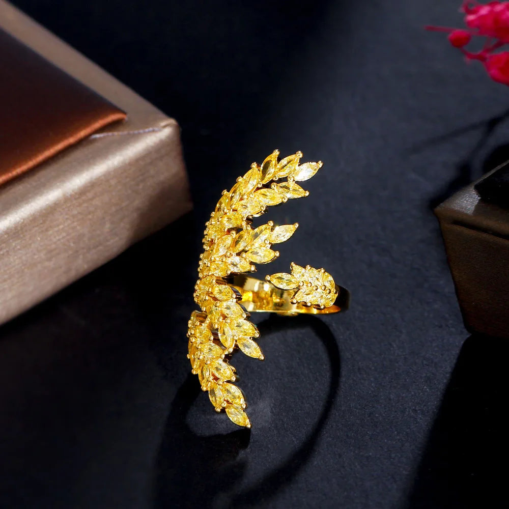 Gold-tone adjustable ring with raised leaves and clear stones, shown from the side
