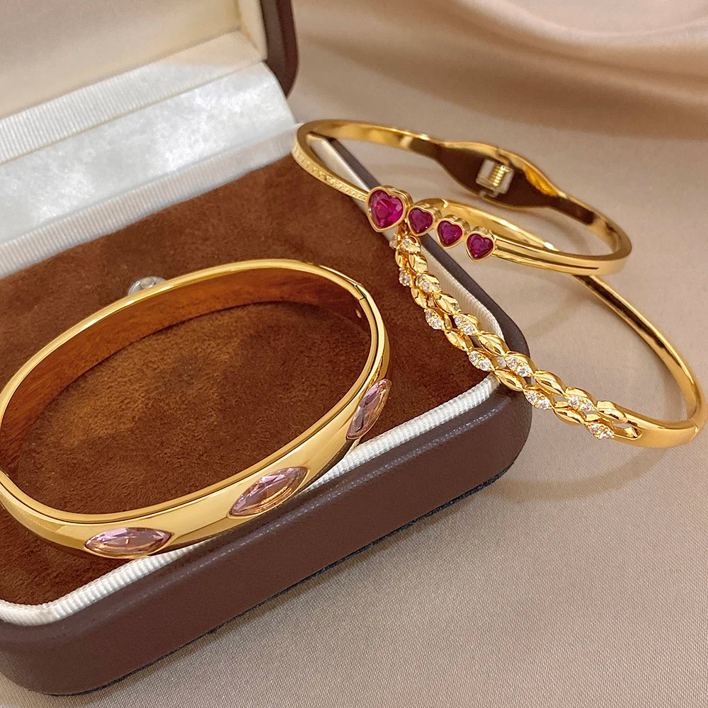 Gold tone cuff bangles with purple heart and pink zircon accents, stackable set
