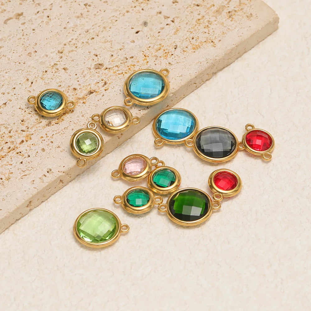 Round faceted glass charms with gold-tone loops in teal, green, red, and gray