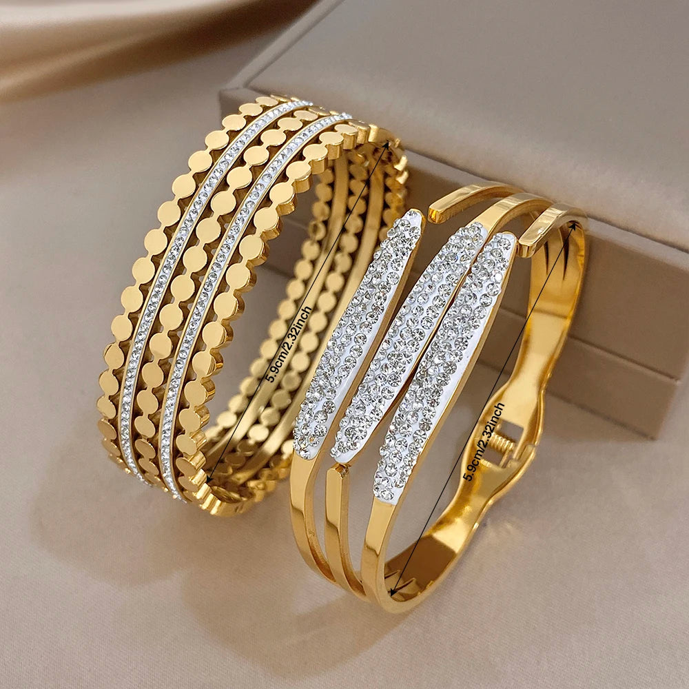 Gold-tone wide cuff bangle with textured geometric links and clear rhinestone bands