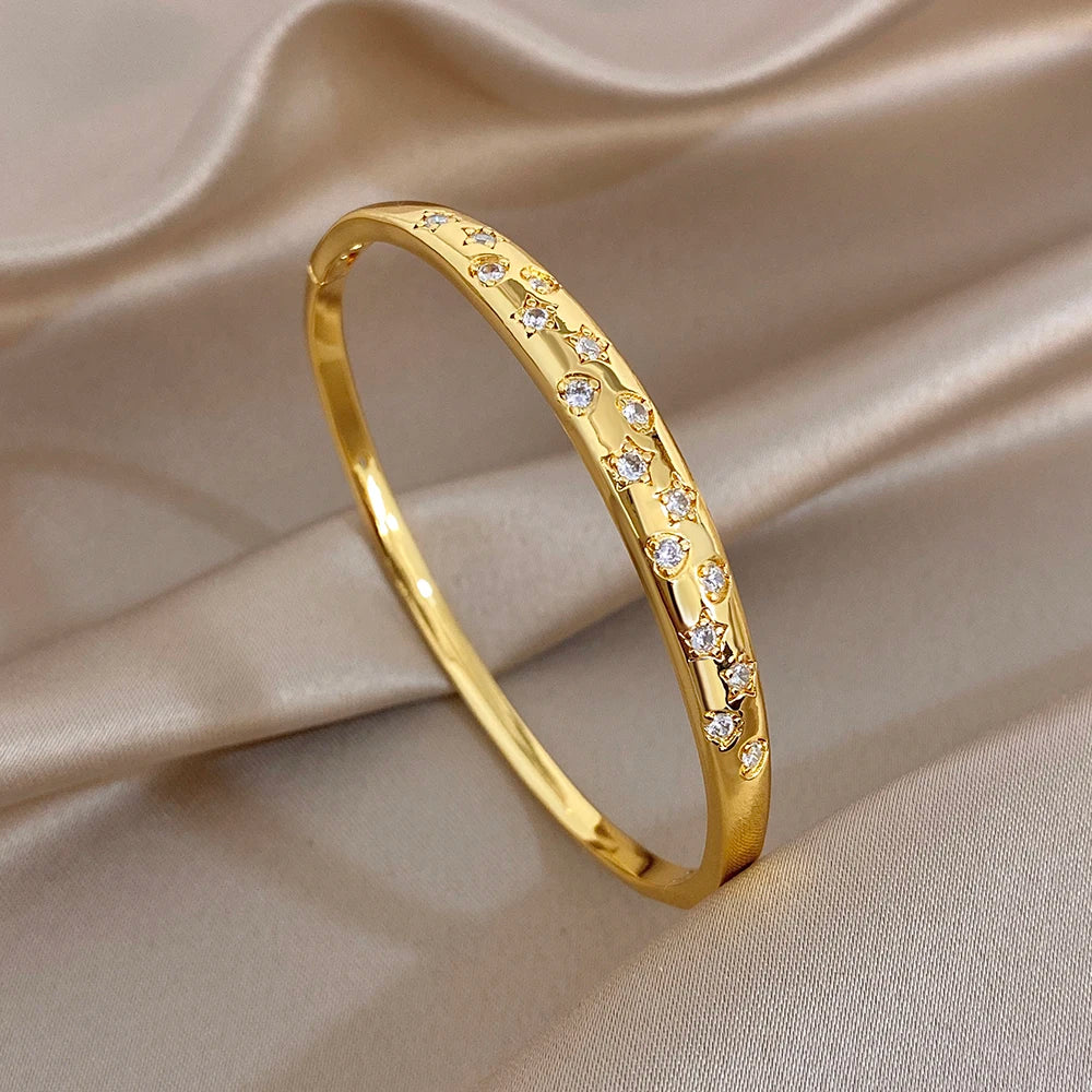 Gold plated cuff bangle with row of clear stones along the front