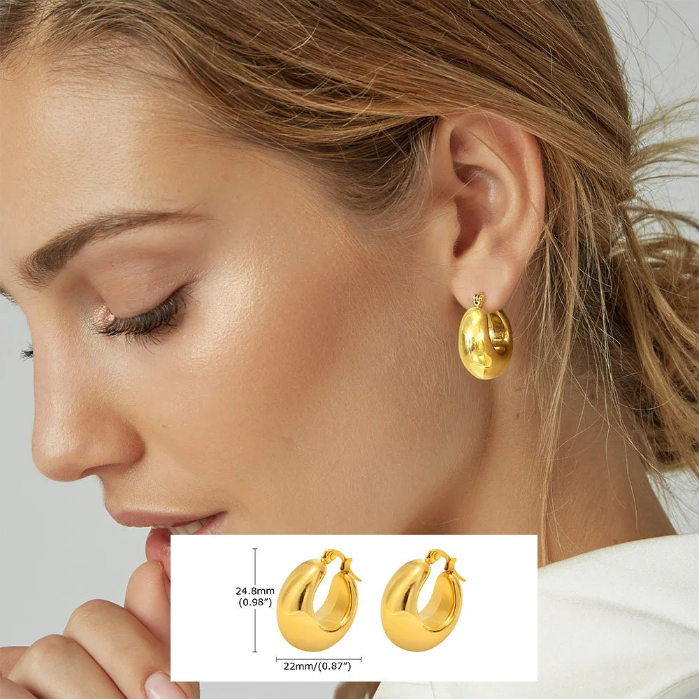 Gold-tone chunky oval hoop earrings with smooth rounded surfaces.