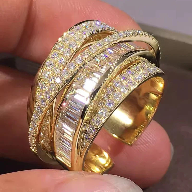 Gold-tone CZ cross-over open band ring, angled side view with baguette details