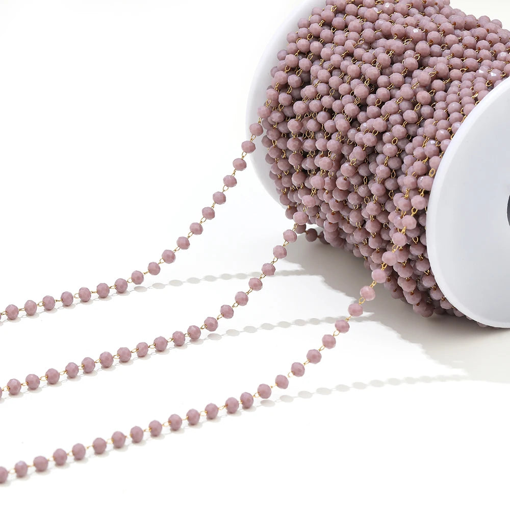 Pink faceted beaded chain on a white spool with two loose strands