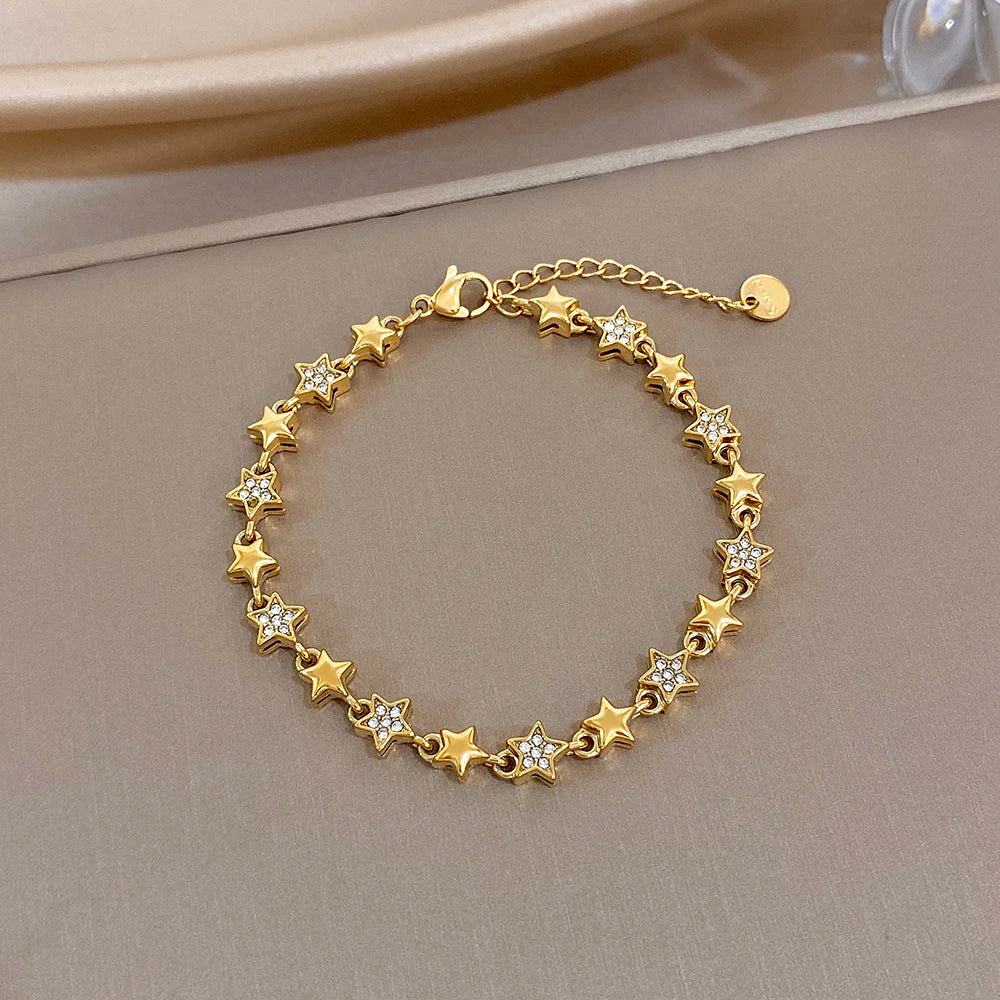 Gold-tone star charm bracelet with multicolor enamel star accents and lobster clasp
