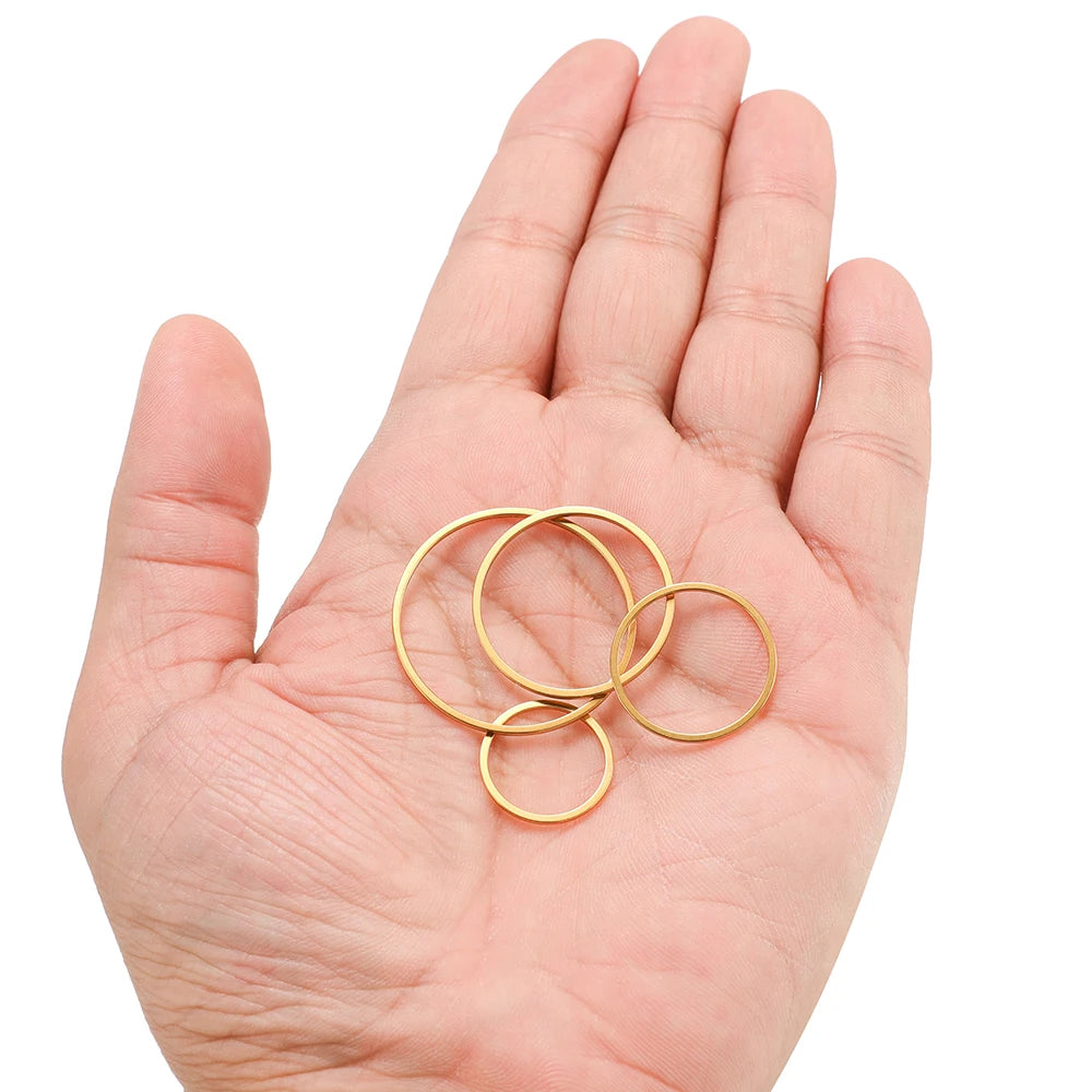 Gold-tone hollow circle bezel charms held in hand, small round wire hoops
