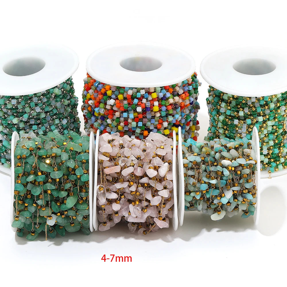 Irregular glass bead link chain rolls in teal, orange, and gold tones on three white spools