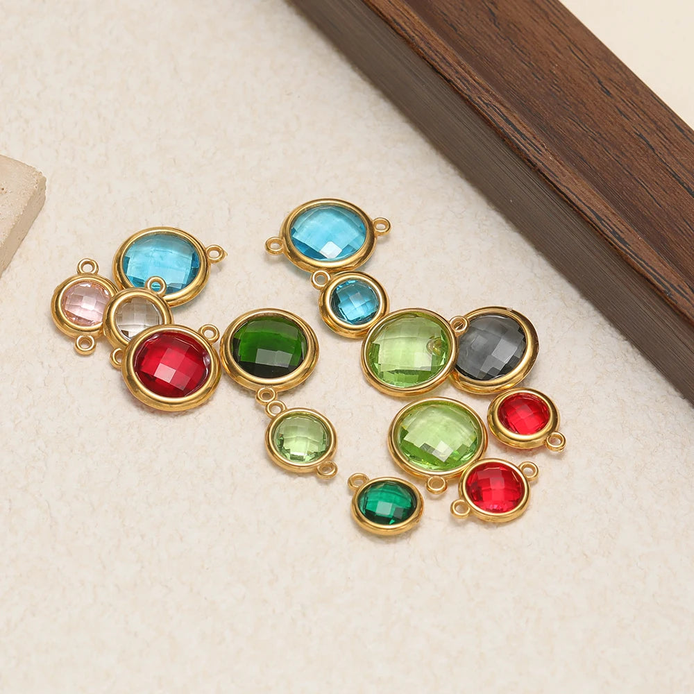 Assorted round faceted glass charms with gold-tone loops in blue, green, red, and clear