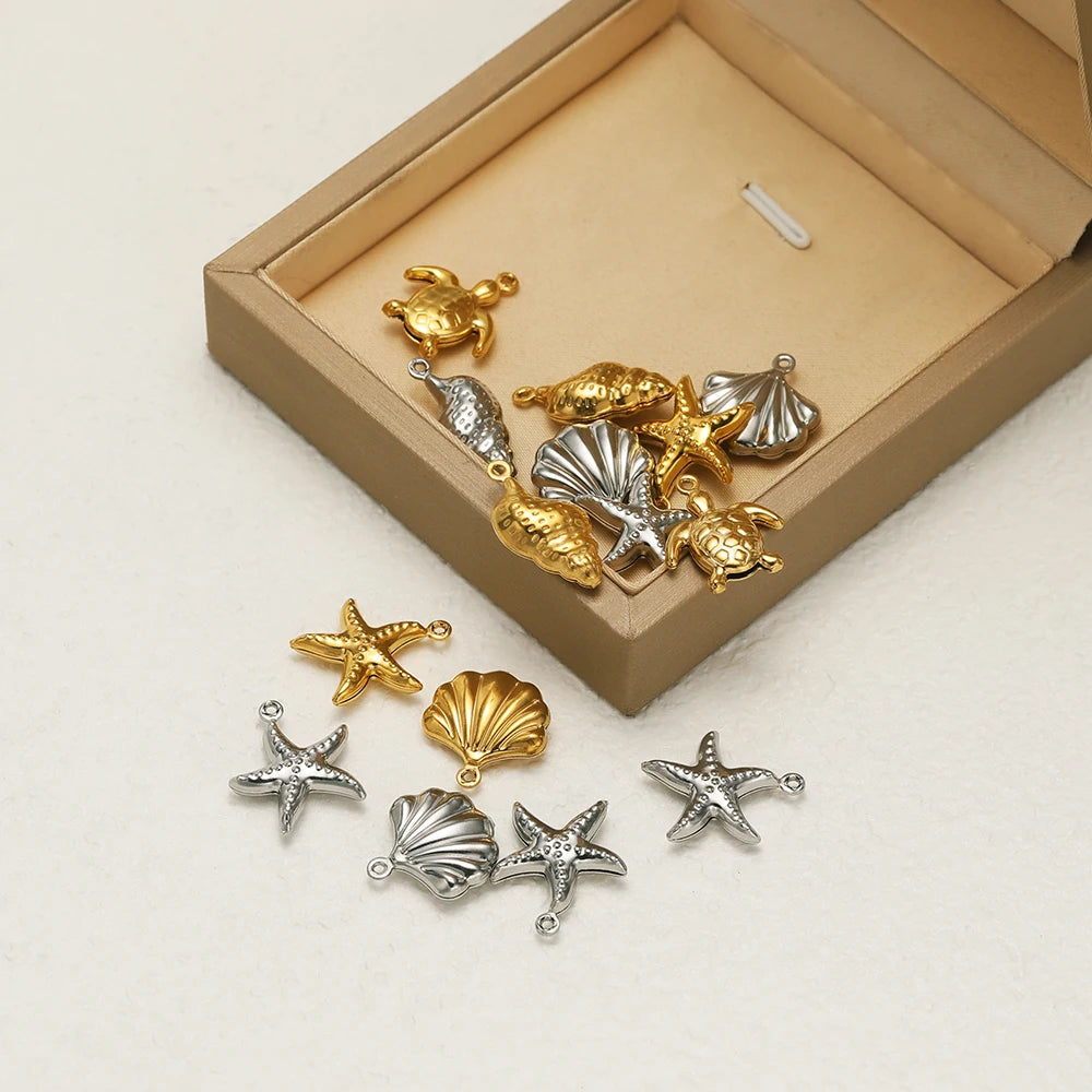 Sea animal charm assortment in gold and silver tones: shells, starfish, turtle, and conch