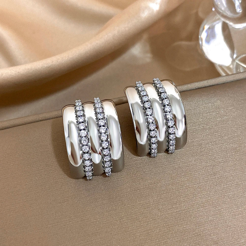 Silver-tone stud earrings with two rows of clear rhinestones and polished ridged bands