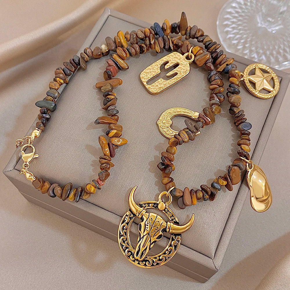 Gold-tone charm beaded necklace on box with bull head pendant, cactus, star and teardrop charms