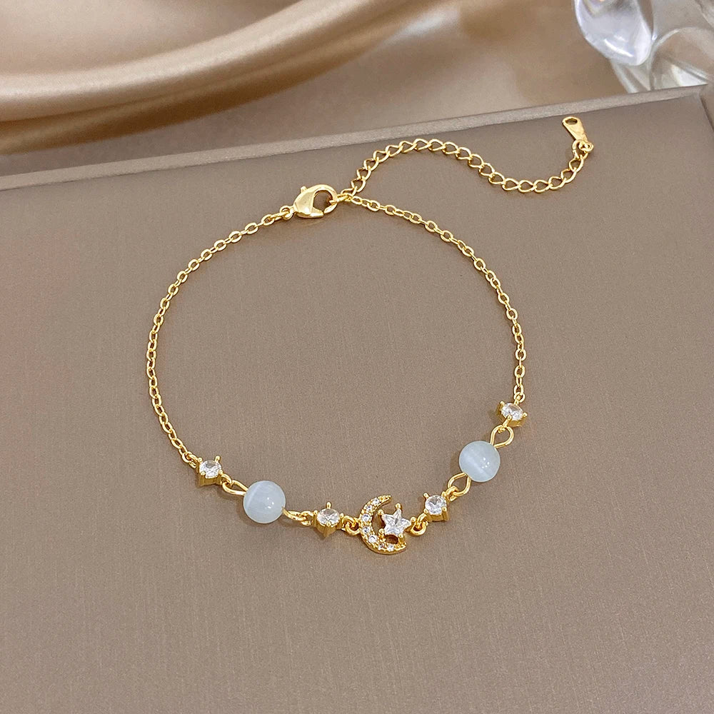 Gold-tone bracelet with white moonstone beads and small starfish charms