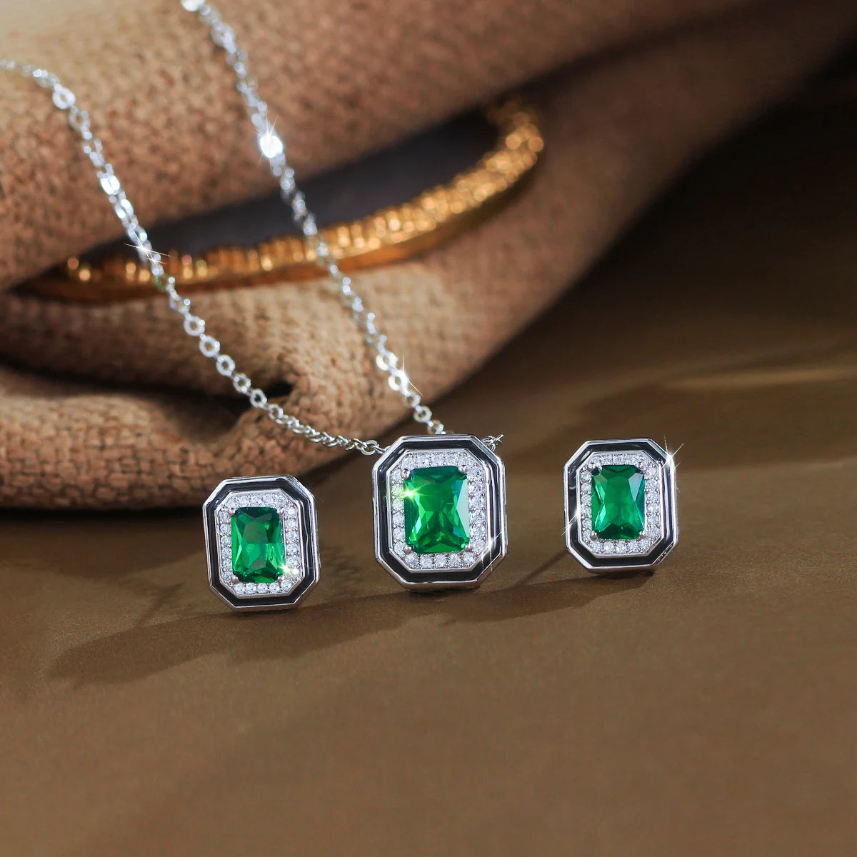 Silver-tone jewelry set with a green rectangular crystal pendant and matching stud earrings