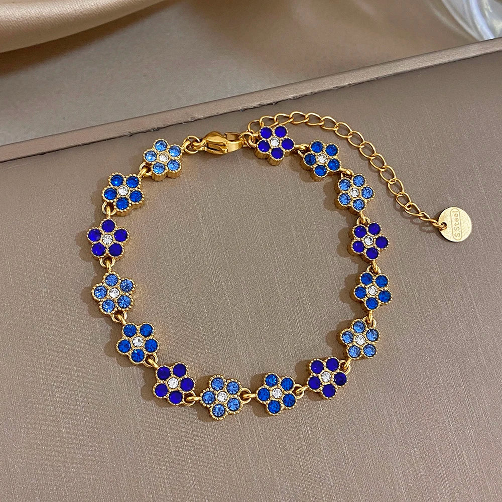 Gold-tone flower zircon bead bracelet with blue four-petal clusters and small round extender tag