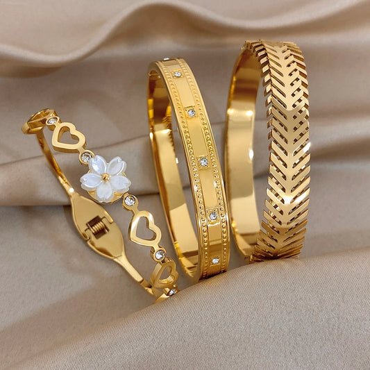 Gold-plated cuff bangles with flower and heart insets, small clear zircon accents