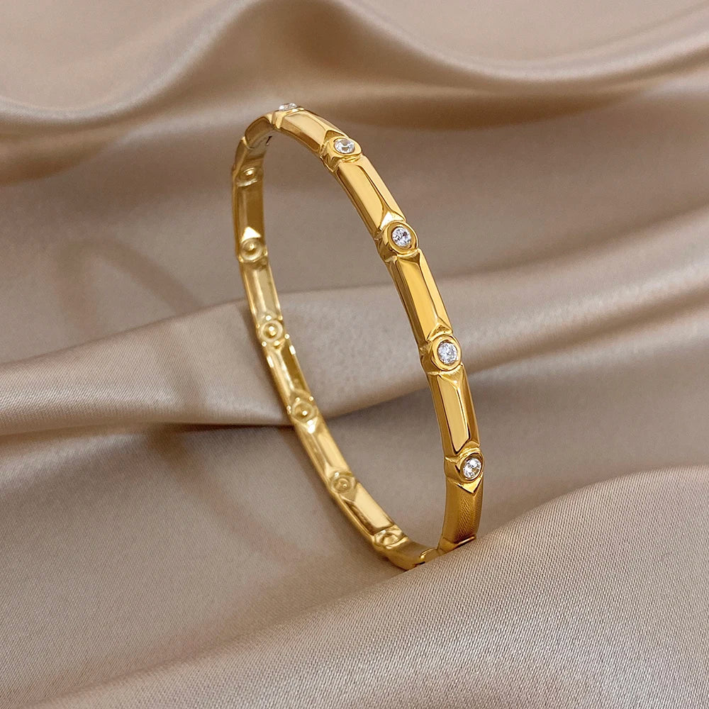 Gold-tone rectangular link cuff bangle with small clear rhinestones along the band