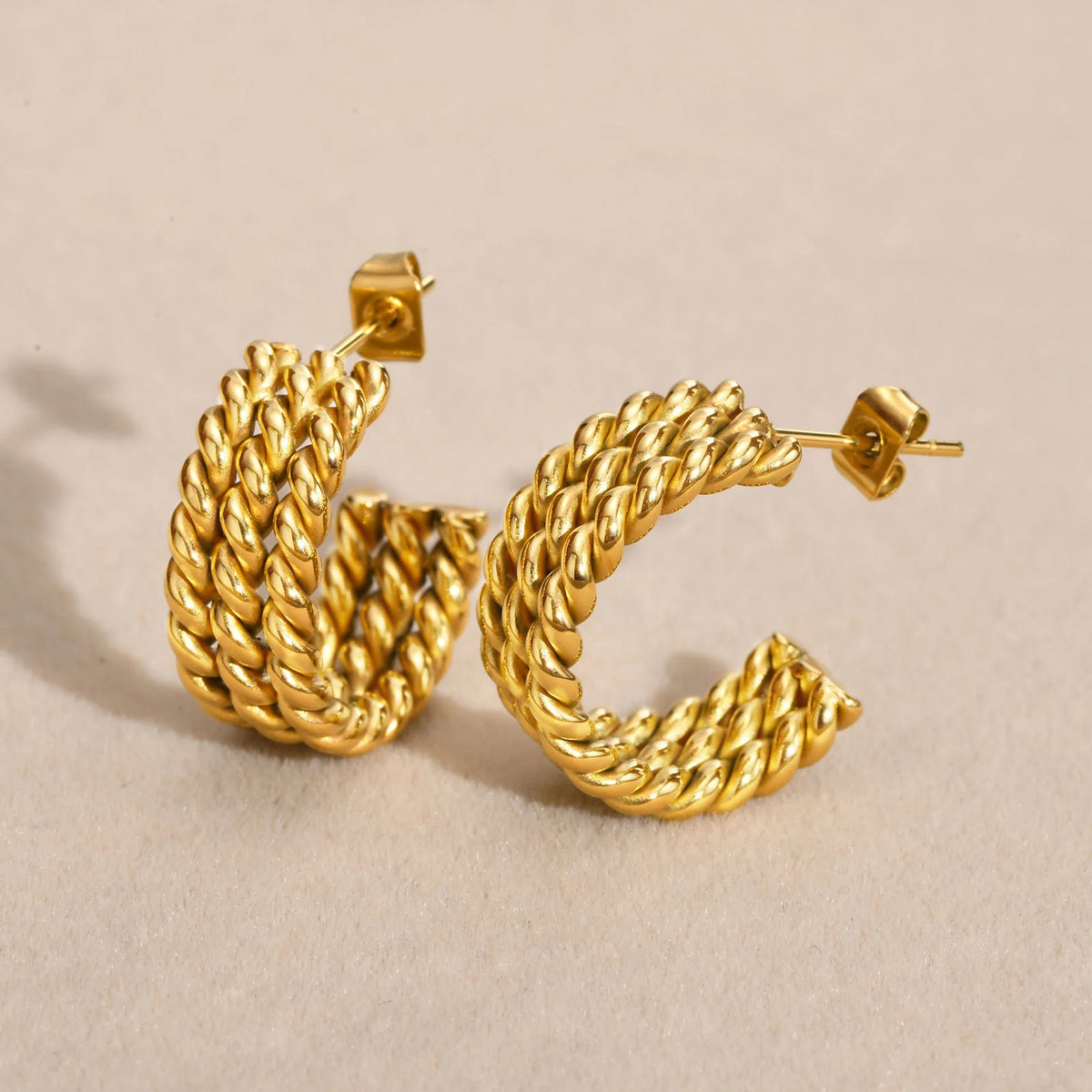 Gold-tone rope-twist open hoop earrings with thick braided bands and post backs