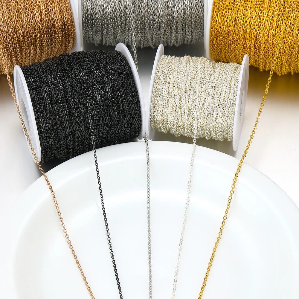 Thin stainless steel chain links on multiple spools in black, silver, rose gold, and gold
