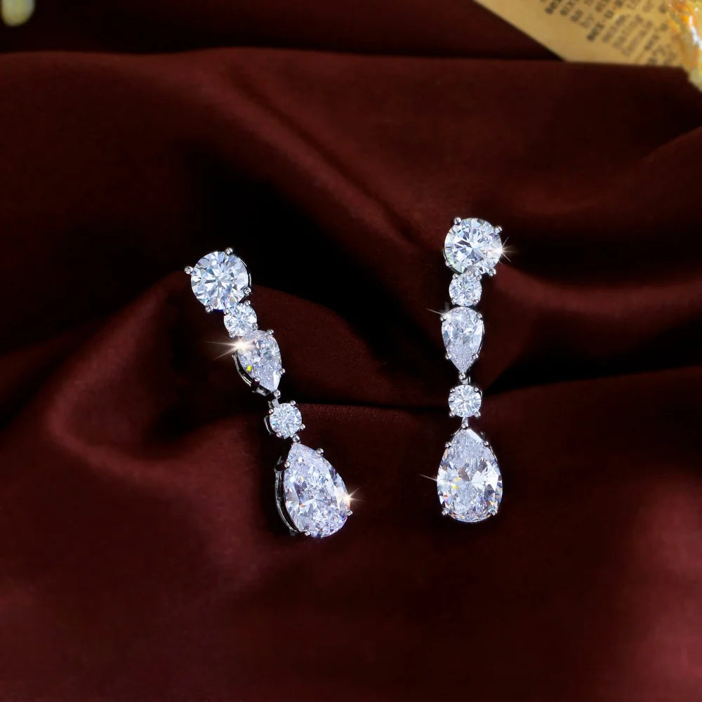 Pair of long cubic zirconia earrings with round, marquise, and pear-shaped stones.