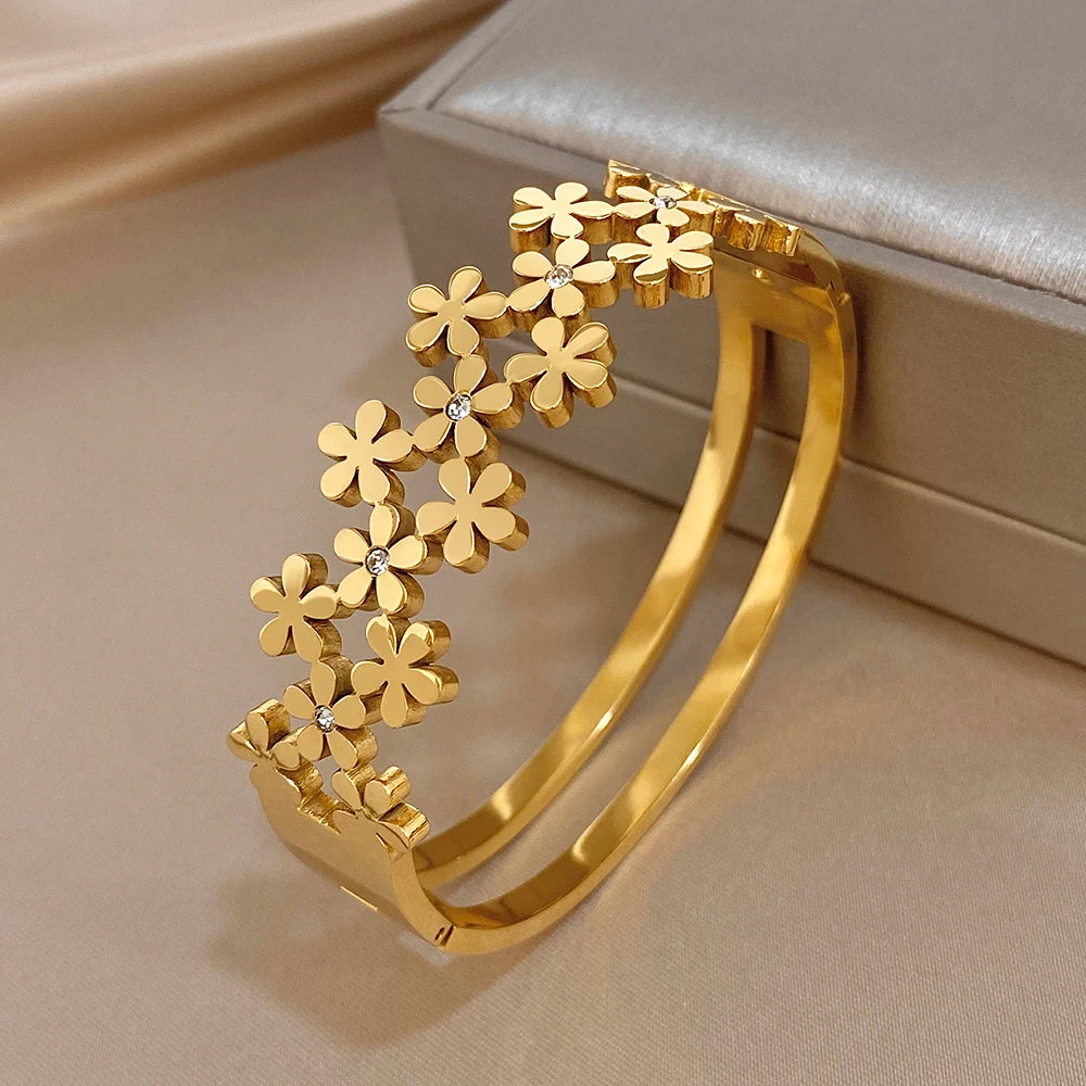 Gold-plated flower wide bangle bracelet with openwork blooms and crystal stones