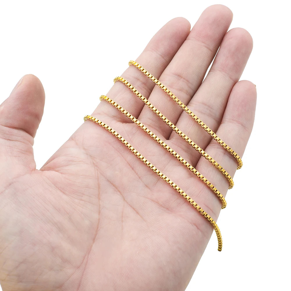 Gold box chain held in a hand, showing thin rectangular link pattern for DIY jewelry