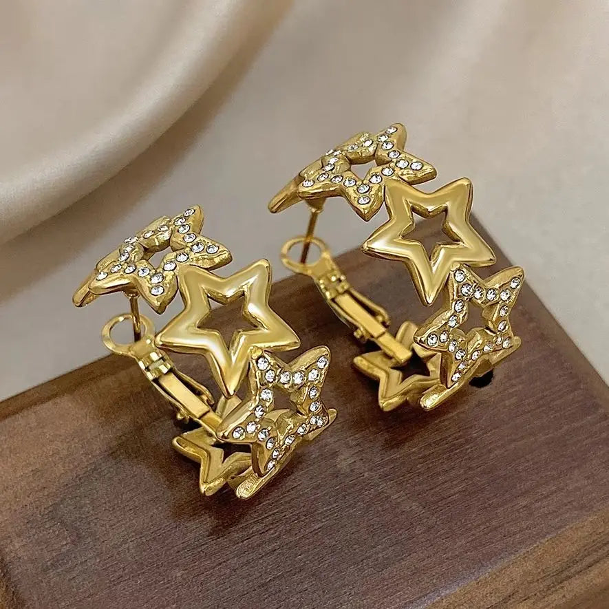 Pair of gold-tone star hoop earrings with open stars and rhinestone details