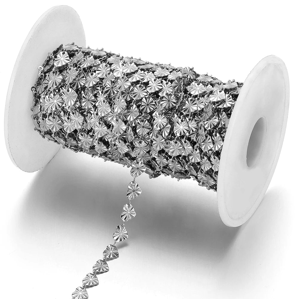 Silver-tone heart-shaped embossed chain draped from two white spools