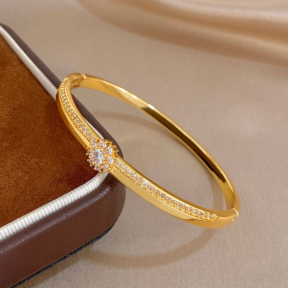 Gold-plated bangle with micro-paved zircon band and flower centerpiece