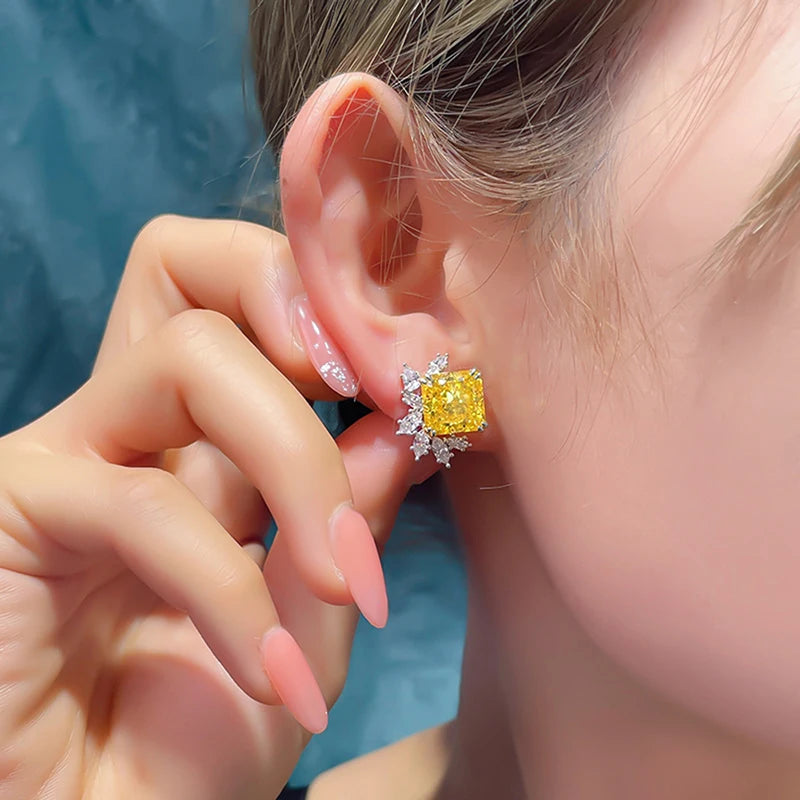 Yellow square cubic zirconia stud earrings with clear crystal halo, worn