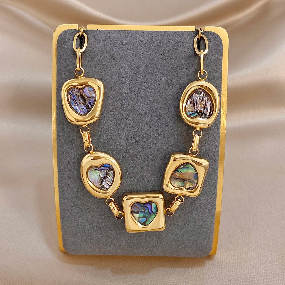 Gold-tone charm bracelet with square and heart iridescent abalone-shell insets on oval links