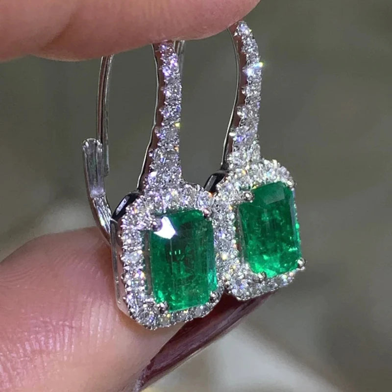 Silver-tone dangle earrings with emerald-green rectangular stones and sparkling clear accents