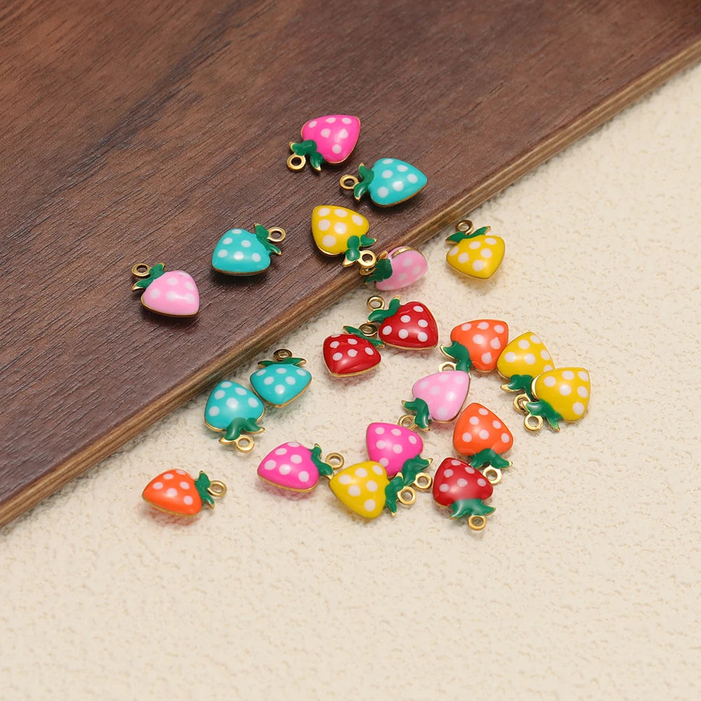 Colorful strawberry drop charms with gold-tone loops and green leaves, polka-dot enamel