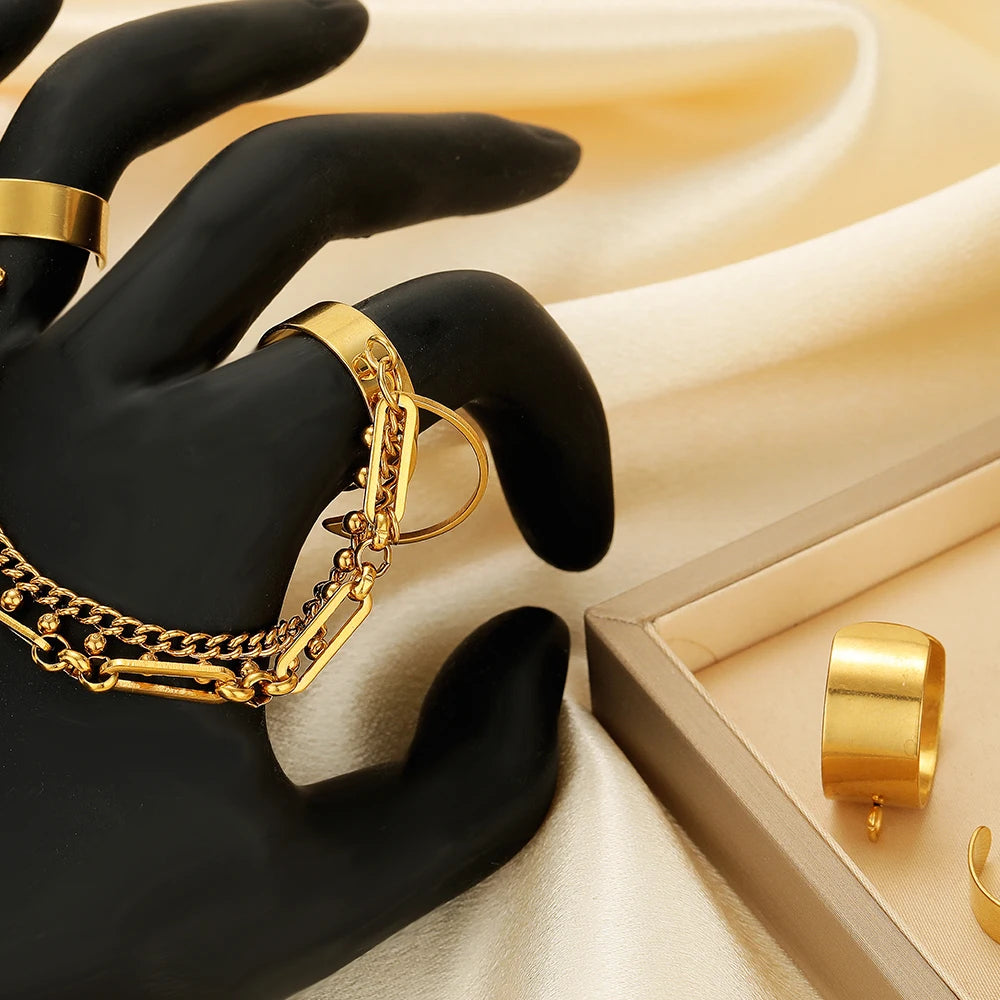 Gold open adjustable ring base with jump ring, held on a black glove