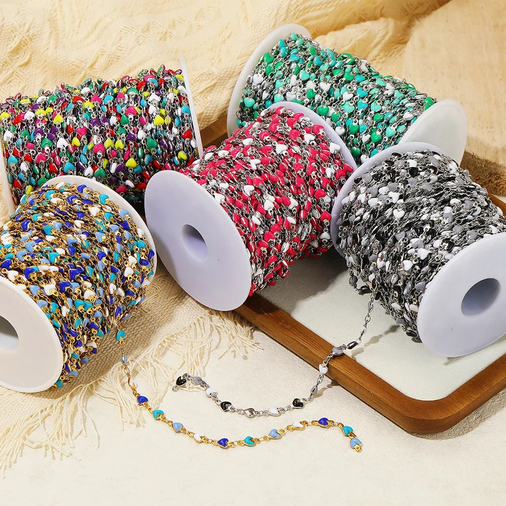 Colorful enamel heart link chain set on reels with blue, teal, gold, and red links