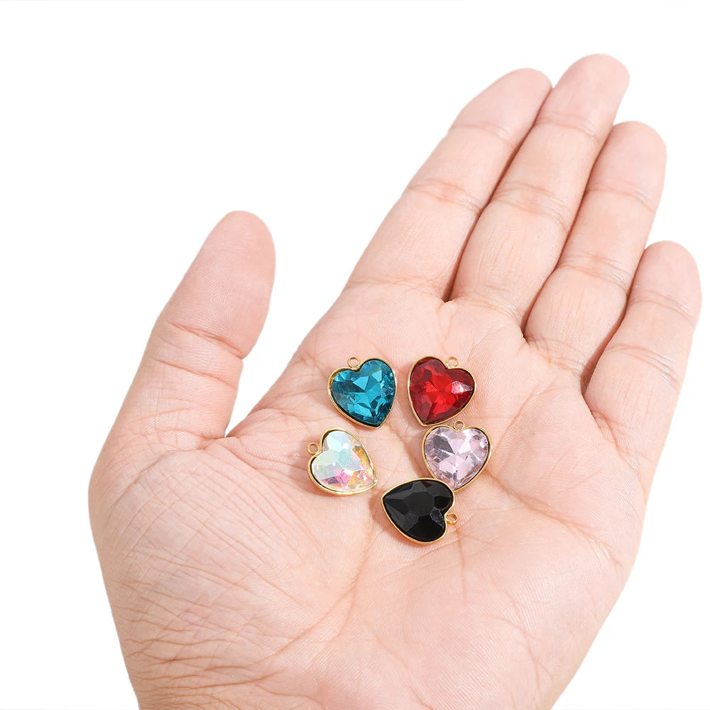 Heart crystal charm pendants set on open hand, gold-tone with blue, red, pink, and black stones