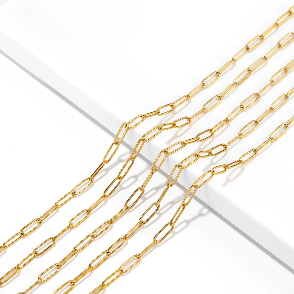 Gold-tone oval flat cable chain close-up with interlocking cross-style links