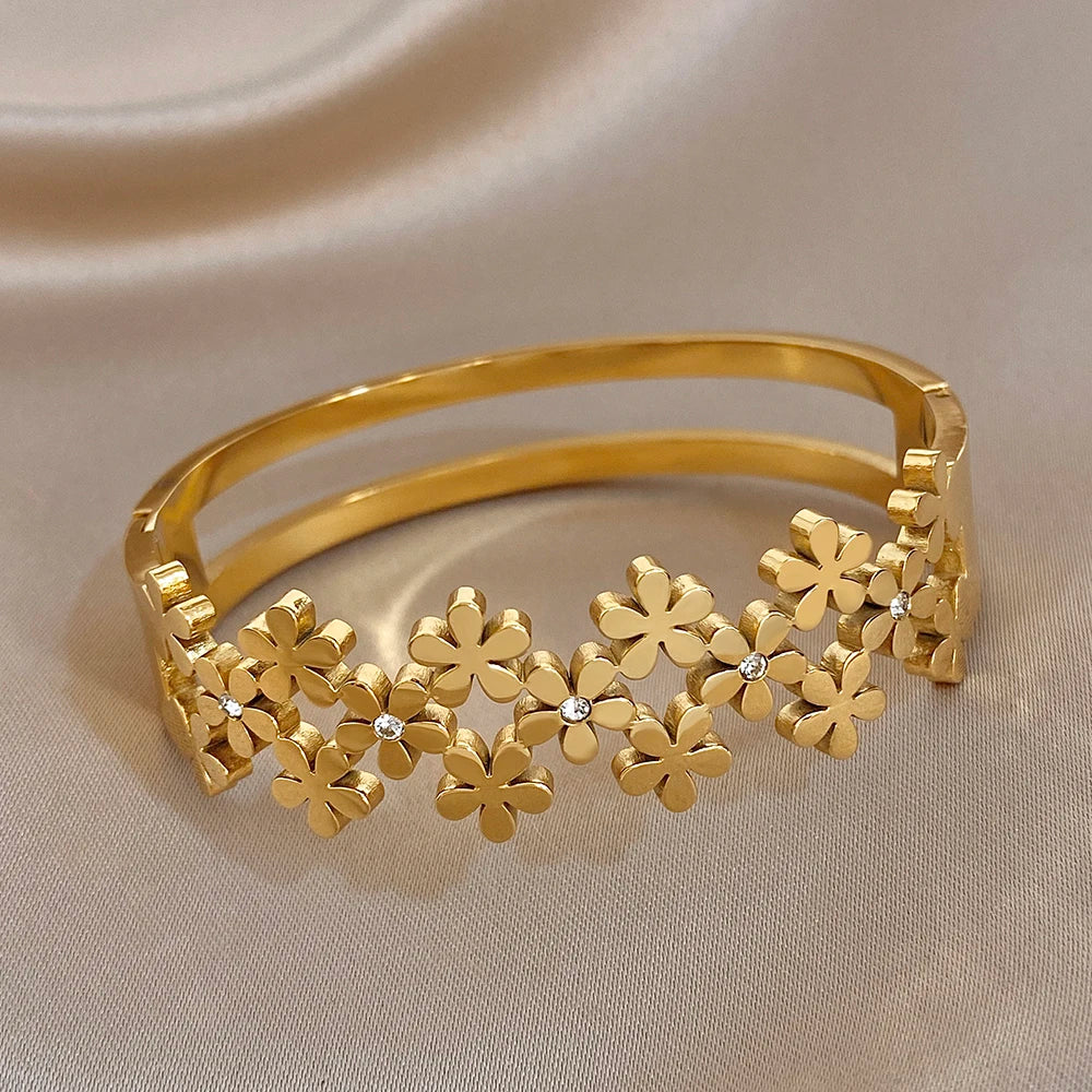 Gold-plated wide bangle with flat flower links and tiny crystal centers