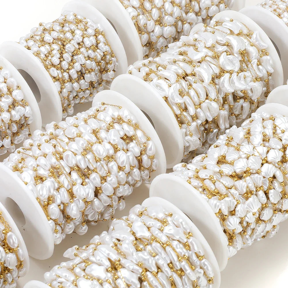 Close-up of white artificial pearl chain spools with gold-tone metal links