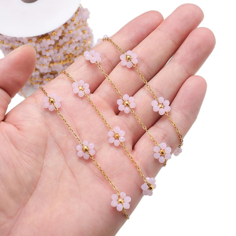Light pink daisy flower beaded chain with gold-tone links held in hand