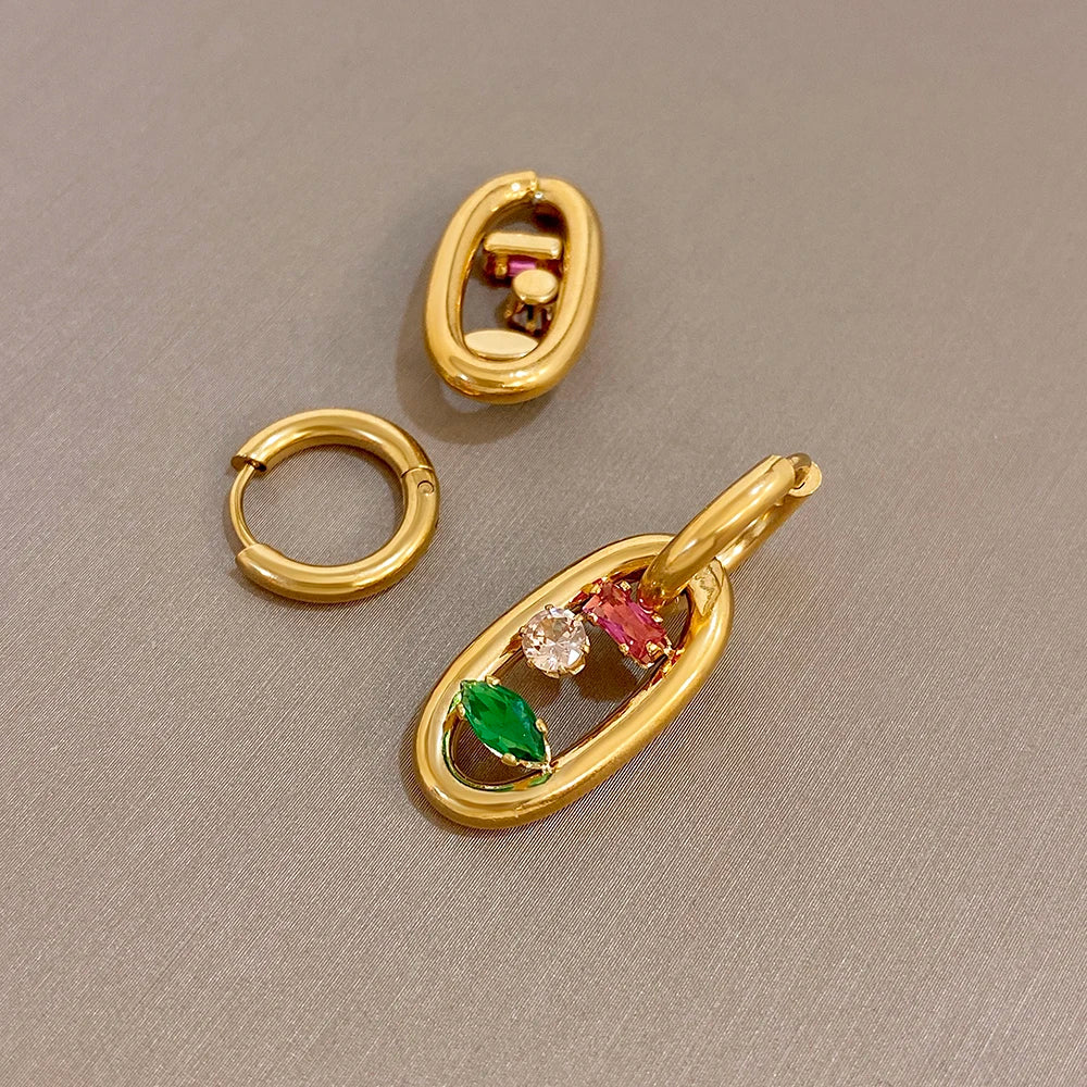 Gold oval hoop earrings with red, green, and clear gem stones inside dangling frames