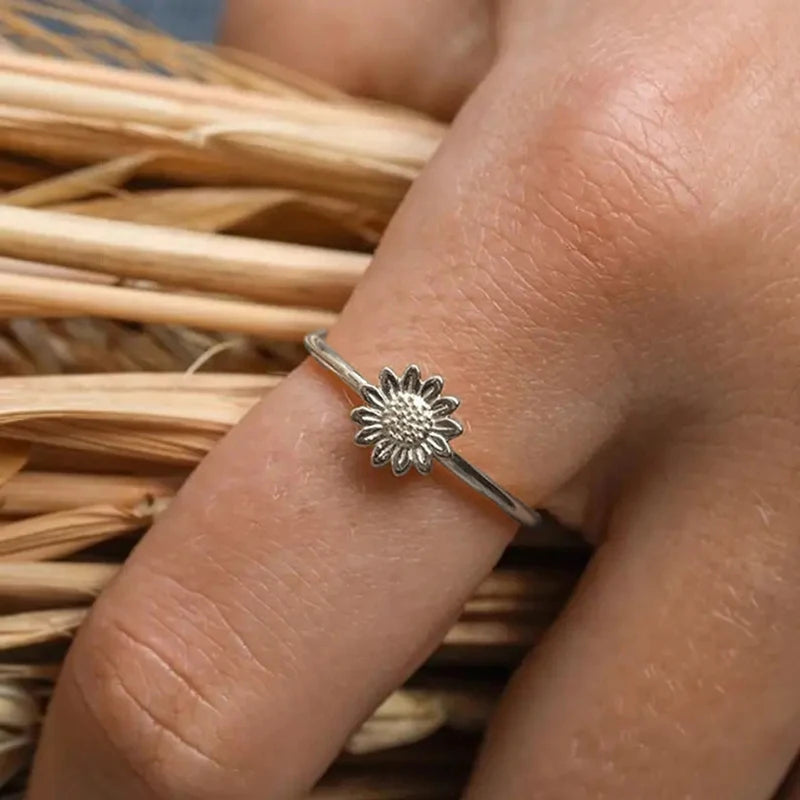 Silver sunflower dainty finger ring with textured flower face on narrow band