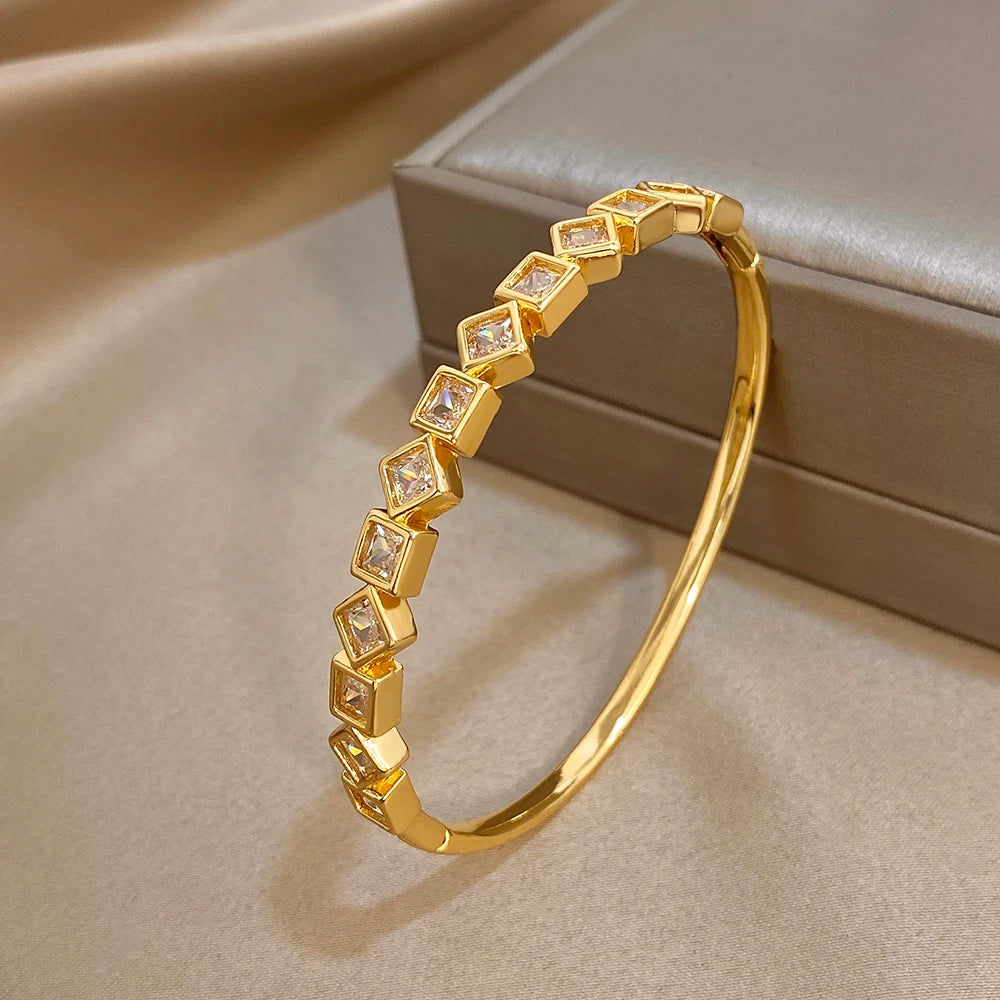 Gold-tone zircon cuff bracelet featuring a full curve of square clear stones