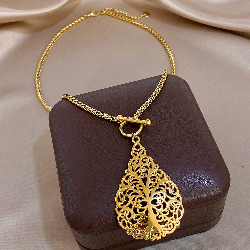 Gold-plated stainless steel necklace with ornate cross pendant and hollow floral cutout design